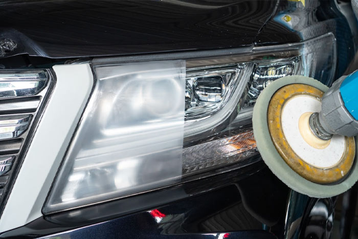a close up of a car headlight being waxed
